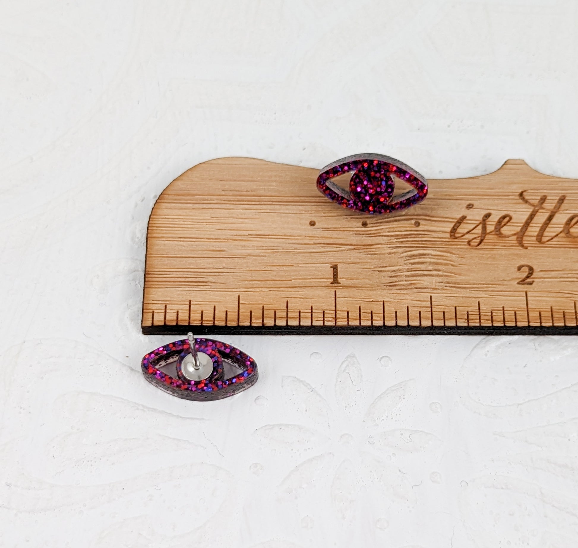 Peepers - Eye shaped stud earrings made with ruby sparkle acrylic and stainless steel posts measured with wooden ruler